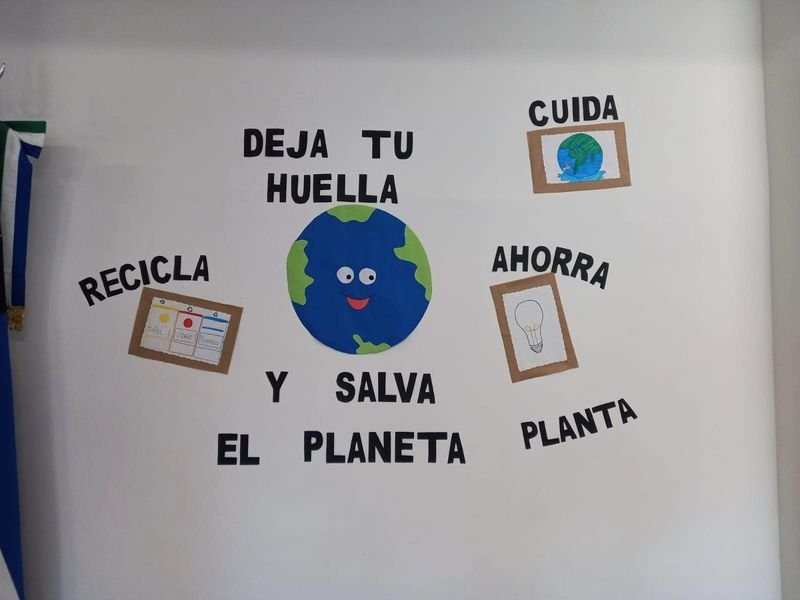 Mural de Educación Ambiental «Deja tu huella y salva el planeta», con una Tierra sonriente y los carteles recicla, cuida, ahorra y planta